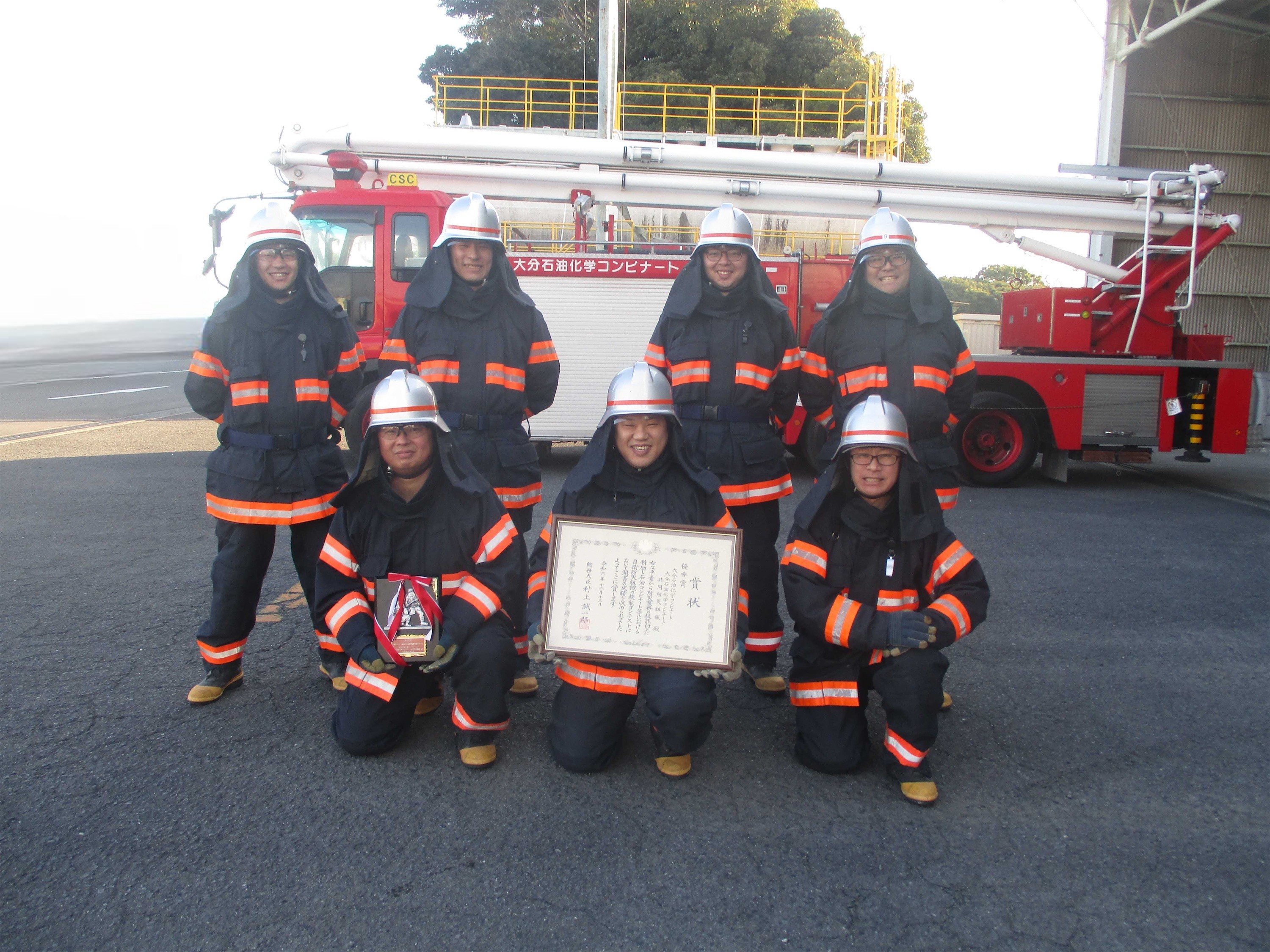 Fire company members showing the award certificate and plaque
